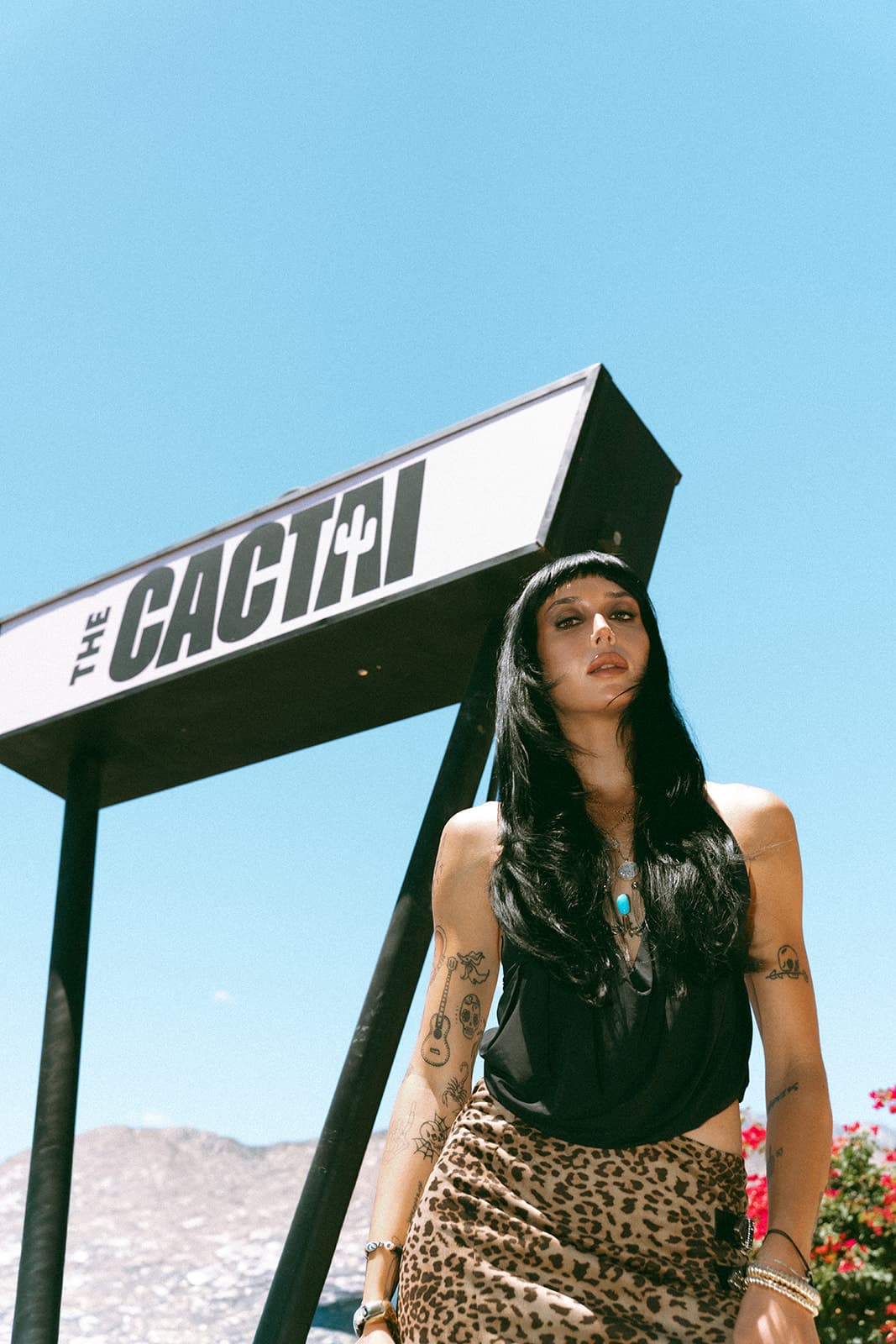Guest posing beneath The Cactai sign